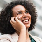 smiling lady while talking someone in a mobile device