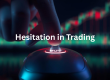 Close-up of a hand hovering over a computer mouse, finger poised above a glowing “BUY” button, with blurred candlestick charts in the background and the overlaid text “Hesitation in Trading”.